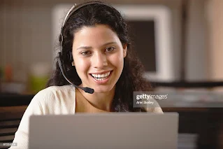 Person wearing headset and working on laptop with Shopify logo and coffee cup