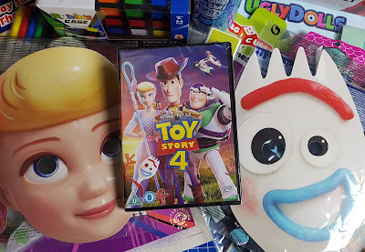 Toy Story 4 DVD and masks on top of random toys and paper