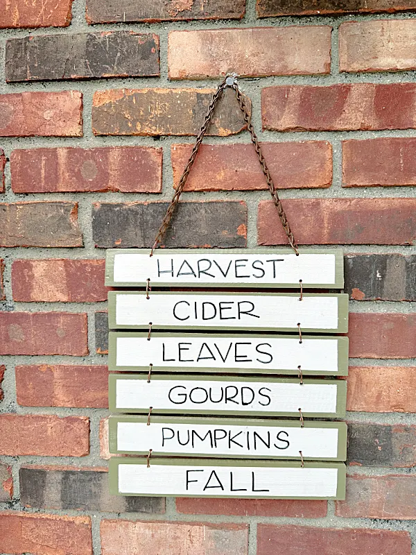 fall sign hanging outside on brick wall
