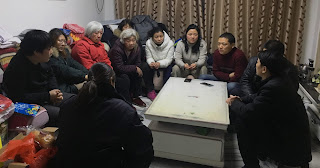 Chinese family huddled round a table