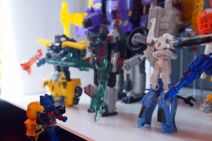 Optimus Prime and Bumblebee taking pictures of a toy display at Cybertron Con 2012