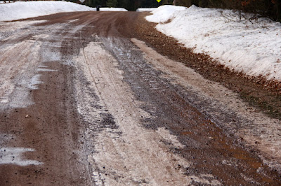 a gravel road early in mud season