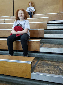 Two children sitting on Manchester Giants Basketball court seating wooden benches