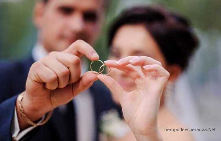 Pareja de recién casados enseñando anillos