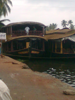 cozy inner and outer view of a giant house boat with two floors- one conference area for around 200 peoples on the top and 6 air-conditioned   luxury bed rooms in the bottom at punnamada finishing point alappuzha backwaters kerala where the World famous Nehru Trophy Boat race happens once in a year