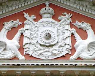 Armas do Império do Brasil no frontispício do Palácio Imperial de Petrópolis (hoje Museu Imperial). Note-se que os ramos de cafeeiro e tabaco estão atados pela fita da Imperial Ordem do Cruzeiro (imagem disponível no projeto A Casa Senhorial).