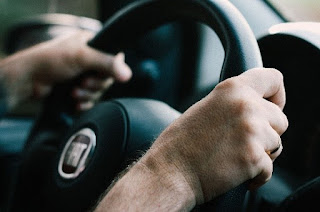 Des mains sur le volant d’une voiture