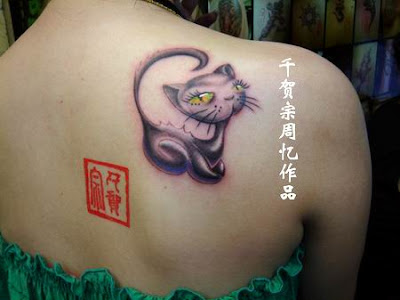 A kitty tattoo on the back with very big and bright eyes