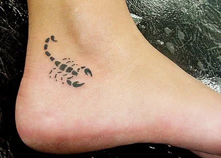 en el tobillo de una chica se ve el tatuaje de un escorpion al estilo tribal