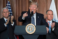 U.S. President Donald Trump speaks between Vice President Mike Pence (L) and EPA Administrator Scott Pruitt prior to signing an executive order on ''Energy Independence,'' eliminating Obama-era climate change regulations, during an event at the EPA (Credit: Reuters/Carlos Barria) Click to Enlarge.