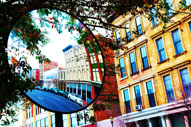 Buildings behind a mirror that has buildings in the reflection in downtown Louisville, Kentucky.