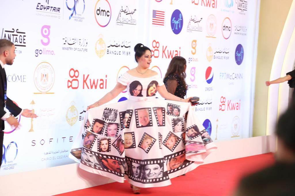 Hind Akef's dress sparks controversy at the opening of the Cairo Film Festival Actress Hend Akef appeared with a different and strange look at the opening of the 44th Cairo International Film Festival.  She wore a white fluffy cape dress, bearing pictures of a number of artists, similar to films.  The dress caused Hind Akef to be embarrassed by the festival's organizers, and she was expelled from the festival and the red carpet because her dress did not match the "dress code" recommended by the artist Hussein Fahmy, "the festival president" days before the festival began.  The artist Hussein Fahmy, president of the 44th Cairo Film Festival, announced the existence of a specific code for the clothes that the guests will wear.  On the red carpet for the opening of the 44th edition of the Cairo International Film Festival, on Sunday night, stars and stars flock with elegant and attractive looks.  The stars are keen to appear with looks that usually steal the lenses of photographers and grab attention and become the talk of the pioneers of social networking sites, whether on "Red Carpet" at the opening, or during the period of the festival held at the Egyptian Opera House.  The star's looks range from elegant and bold, distinguished and traditional, to bad or inappropriate, throughout the days of the festival, which takes place from 13 to 22 November.