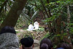 priestesses in white making offerings in Okinawa jungle