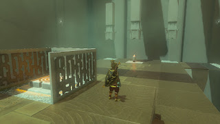 inside a shrine next to a switch and with three shafts in the distance and a candle below one of them