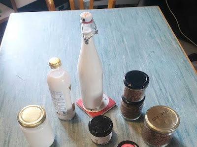 Various containers with almond milk and almond spread.