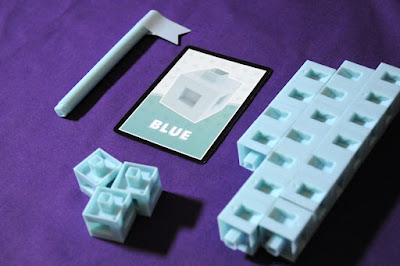 Close up of blue pastel components from the boardgame Ctrl with one flag and one card that reads "Blue"