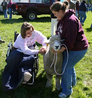 Kaitlyn Fuss (Frederick County) examines the fleece of a Romney ewe held by UMES student Shannon Uzelac