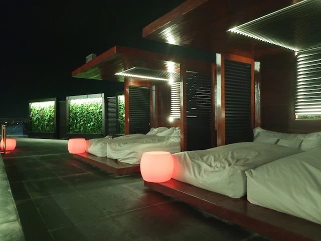 " Pool beds and tables on the rooftop of Yogh Hospitality Hotel in Suriname. The tables light up during the night"