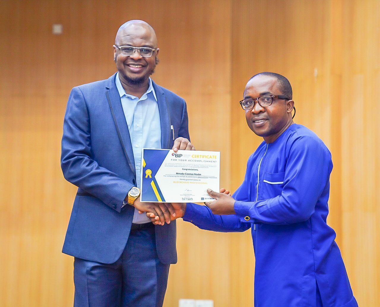 Minister of Digital Economy, Prof. Isa Ali Ibrahim, presents certificatento "selected graduates" of the 32,022 Nigerians trained on Blockchain Technology by the Federal Government