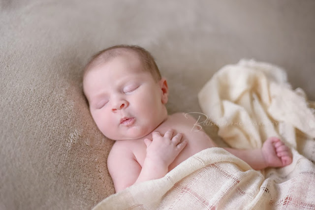 newborn baby girl sleeping on brown blanket