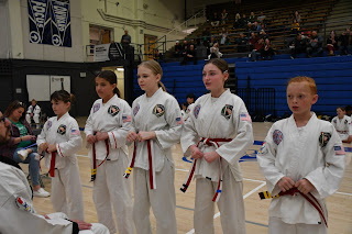 A group of teenagers doing taekwondo at a tournament