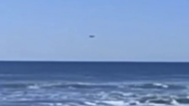 UFO over the ocean water filmed from the beach.