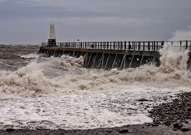 Photo of a wave being blown across the pier at Maryport