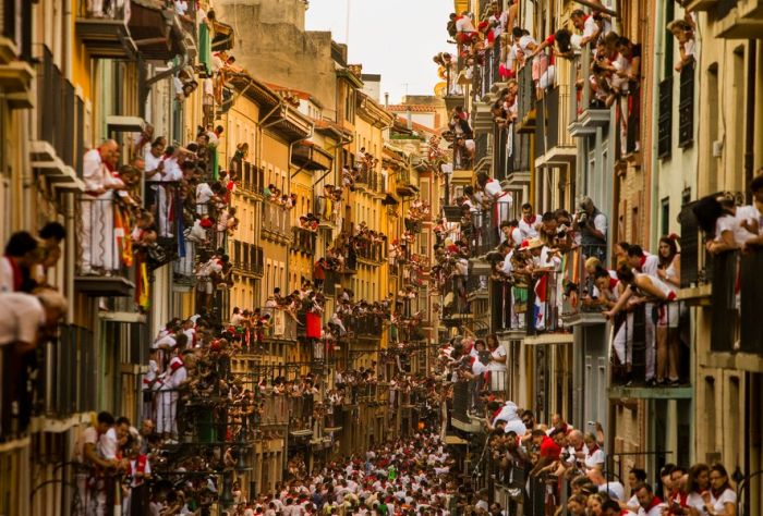 People watching the Running of the Bulls in Pamplona, ​​Spain. Running of the Bull is part of San Fermin, and people come to Pamplona from all over the world to celebrate this festival every year. This kind of scene in the narrow streets will appear once a day in the eight-day event.