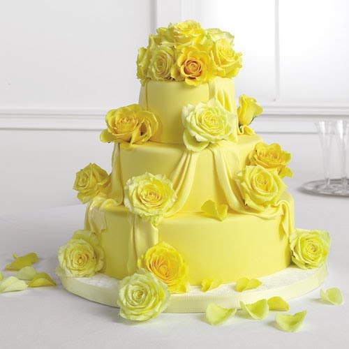 Elegant and joyful three tier yellow wedding cake with fresh yellow roses