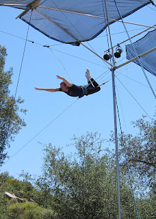 Noah looking for the catch bar in a knee hang on the flying trapeze.