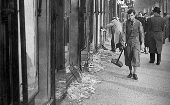 A boy cleans the street after Kristallnacht (November 10, 1938)