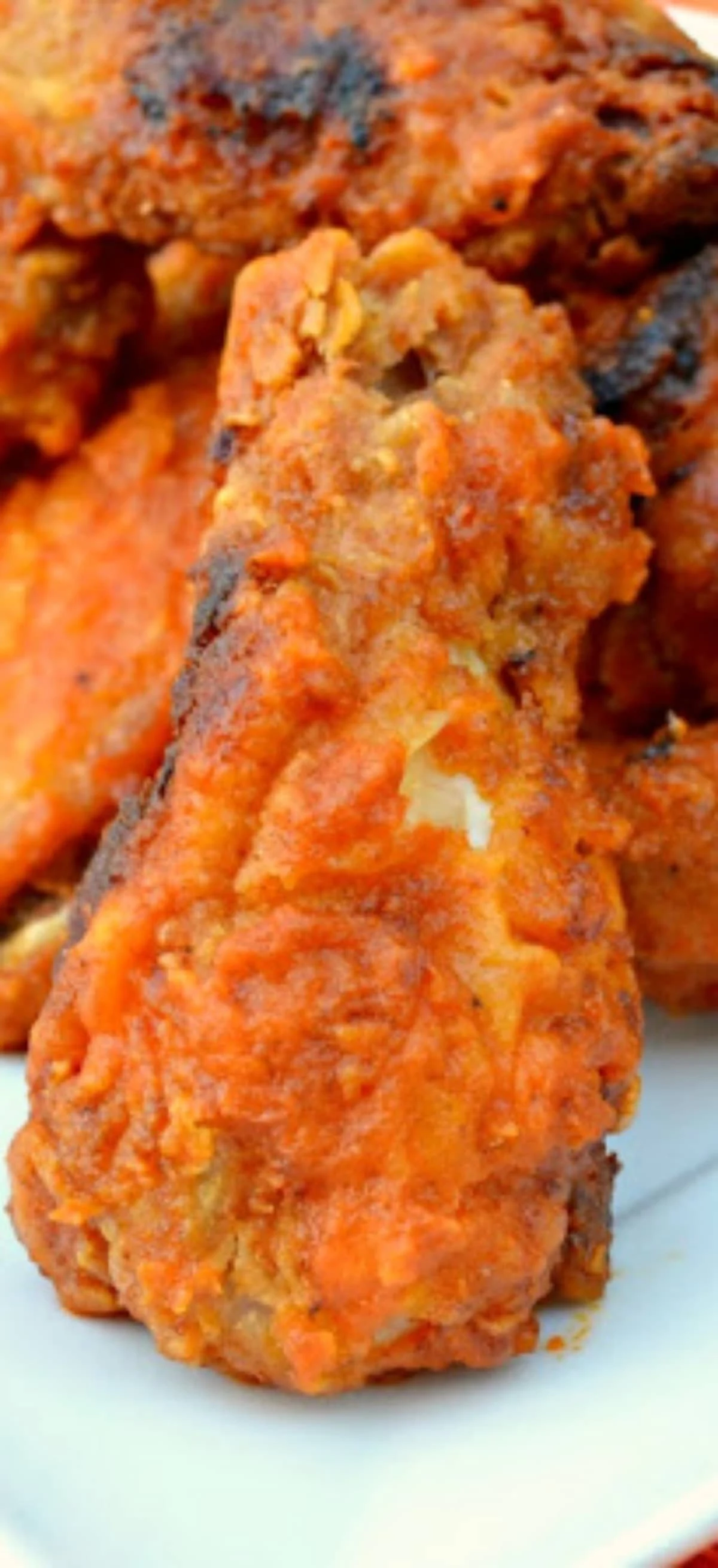 A close up of a Fried Hot Wings on white plate.