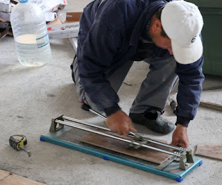 Bekir cutting up tiles to edge in the Art Room