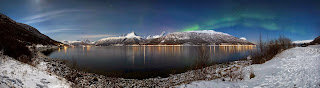 A wide view over Storfjorden (a part of Lyngen fjord) on a winter night in 2012 March. Some Aurora borealis (known as the northern lights) are running across the sky. The summits lighted by the Moon on the other side of the fjord belong to the Lyngen Alps (Lyngsfjellan). Also the planets Jupiter and Venus are quite near to each other (the bright dots, centre left) — Ximonic (Simo Räsänen) — CC-by-SA-3.0