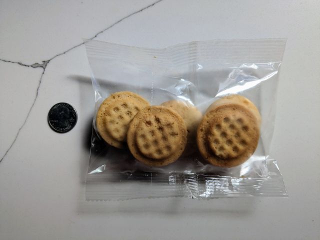 A individual pouch of MyMochi Original Waffle Bites next to a quarter.