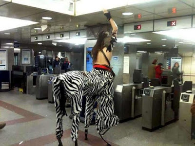 Shirtless man wearing zebra centaur costume at station