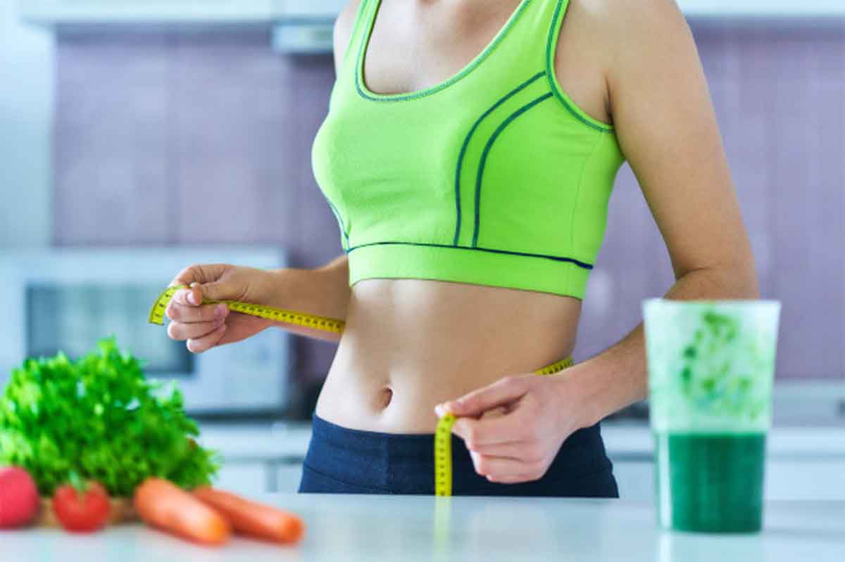 Diet woman in sport wear with measuring tape