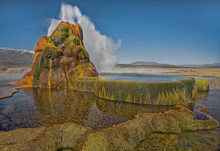 Fly Geyser is a little-known tourist attraction, even to Nevada residents. It is located near the edge of Fly Reservoir and is only about 5 feet (1.5 m) high, (12 feet (3.7 m) counting the mound on which it sits). The Geyser is not an entirely natural phenomenon, and was accidentally created in 1916 during well drilling. The well functioned normally for several decades, but in the 1960s geothermally heated water found a weak spot in the wall and began escaping to the surface. Dissolved minerals started rising and accumulating, creating the mount on which the geyser sits, which continues growing. Today water is constantly spewing, reaching 5 feet (1.5 m) in the air. The geyser contains several terraces discharging water into 30 to 40 pools over an area of 30 hectares (74 acres). The geyser is made up of a series of different minerals, which gives it its magnificent coloration.