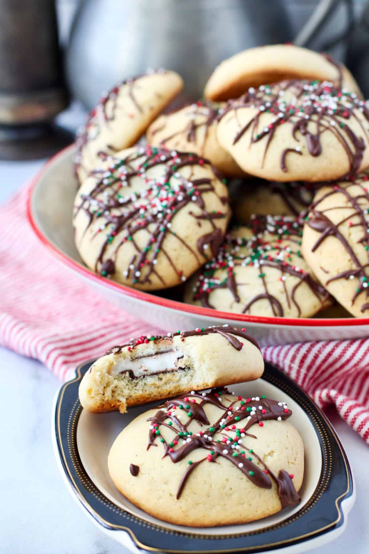 Peppermint Patty Stuffed Cookies with a bite out on a plate in front of a bowl.