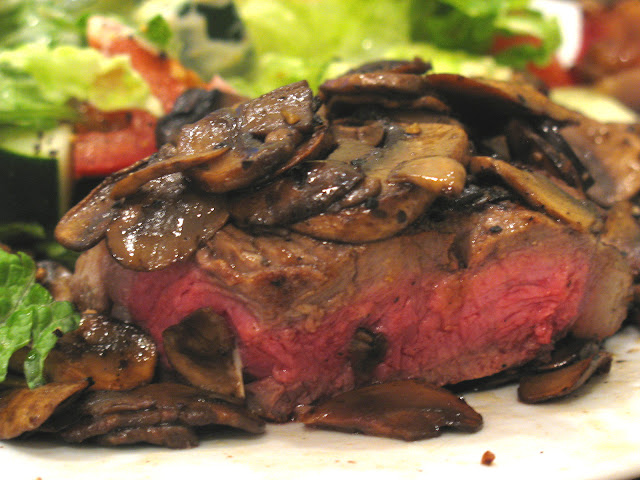 medium rare New York strip steak with mushrooms