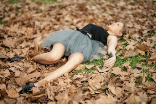 Woman lying in leaves instead of writing