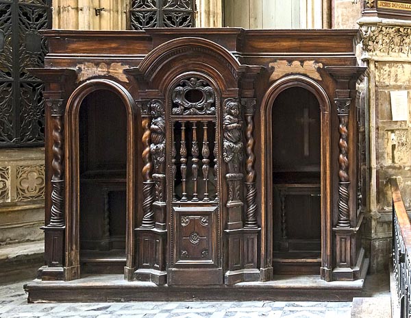an ornate piece of cabinetry with two doors facing front, and crosses inside, in a church