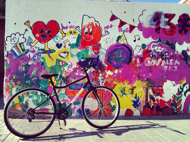 BikeAlao trekking bike in front of colourful street art in Cabañal