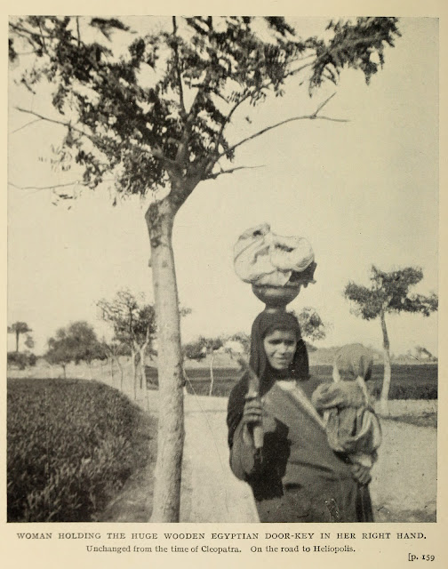 في الطريق إلى هليوبوليس، امرأة تحمل في يدها اليمنى مفتاح خشبي كبير لباب الدار