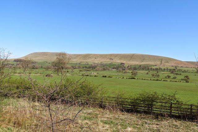 A view of Pendle Hill in its entirety from the drive home, stretching across the horizon under cloudless blue skies.