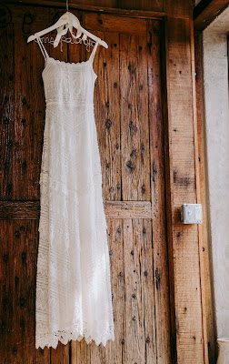 Vestido de novia colgado de una percha sobre un fondo de madera