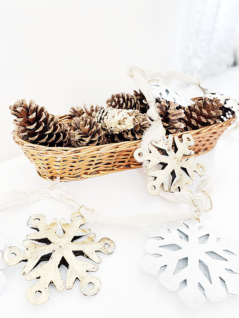 basket of pinecones and metal snowflakes