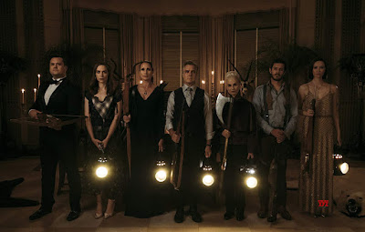 "Ready or Not" (2019) movie still where Kristian Bruun, Melanie Scrofano, Andie MacDowell, Henry Czerny, Nicky Guadagni , Adam Brody, and Elyse Levesque stand next to each other with their old fashioned weapons drawn