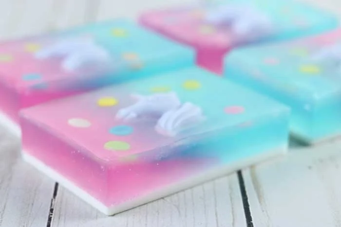 How to make a fun unicorn soap with melt and pour soap. Learn how to use unicorn embeds to make an awesome bar of soap that is great for kids or for gifts. Make a DIY soap with a natural fruity fragrance or use essential oils.  How to make handmade soap with this tutorial for a gradiant background. This fun designs can be used to make other products. Use a unicorn and rectangle mold for this recipe. Learn a new soapmaking technique. #soapmaking #unicorn