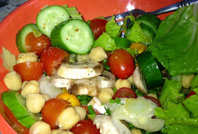 chunks of cut up cucumber, tomato, chick peas, lettuce